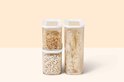 Trois boîtes de conservation Mepal Modula empilées et côte à côte. Deux avec couvercles blancs, remplies de haricots blancs et bruns.