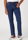Man in donkerblauwe Wrangler jeans, gedragen met bordeauxrode sneakers.