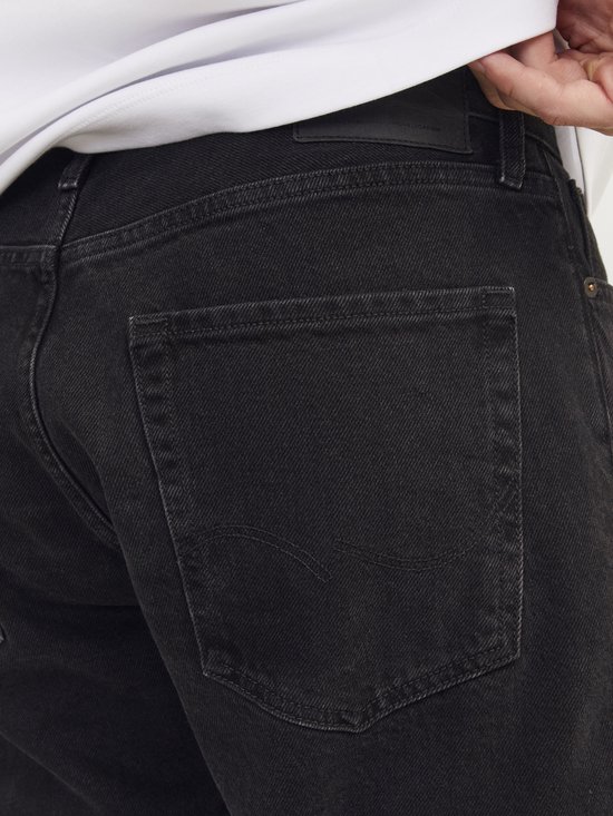 Zwarte jeans, achterkant met zakken en koperkleurige details.
