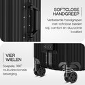 Close-up van de softclose handgreep en de vier wielen van een zwarte koffer. Tekst over stijl, comfort en soepele beweging.
