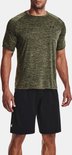 Man draagt een olijfgroen gemêleerd Under Armour sportshirt met korte mouwen en zwart broekje.