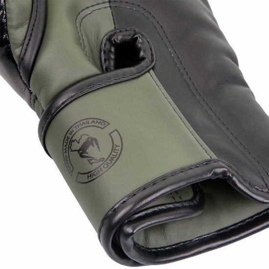 Detail van khaki en zwarte bokshandschoen met tekst "Hand made in Thailand" en "High Quality".