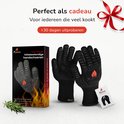 Zwarte, hittebestendige handschoenen van Xamax met rode vlam-logo, verpakt in een doos en los.