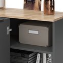 Detail van een open kastdeur van een antraciet dressoir met houten blad, met een opbergdoos en boeken.