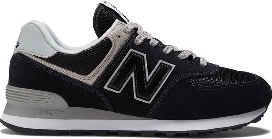 Zijkant van een zwarte New Balance 574 sneaker met grijze en witte accenten.