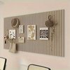 Panneau d'affichage marron à côtes verticales, décoré d'un chapeau, d'images, d'un sac et d'un nœud en corde.