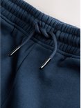 Close-up van de marineblauwe joggingbroek met elastische taille en trekkoord.