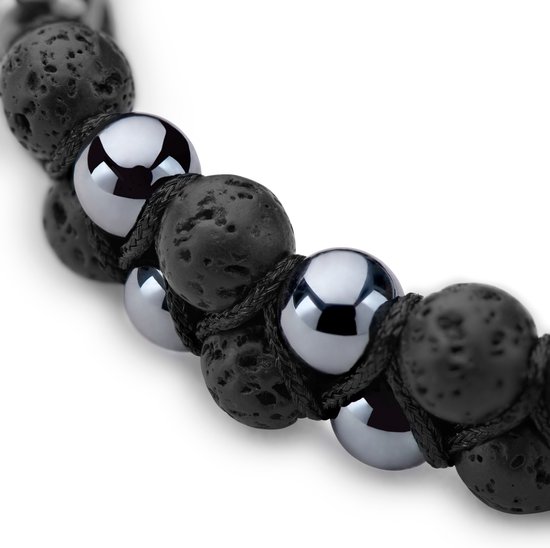 Detail van een dubbele armband met poreuze zwarte lavastenen en glanzende grijze hematiet kralen.