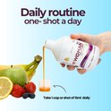 Fles Woman 50+ Multivitamin wordt gegoten in een dopje. Met bananen, aardbeien, bosbessen, citroen en appel.