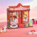 Miniatuur speelgoedwinkel 'Playland of Wonders' met rode gevel, stenen print, een roze hobbelpaard en speelgoed displays.