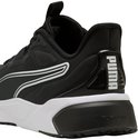 Zij-aanzicht van de zwarte PUMA sportschoen met witte zool en Puma-logo op de hiel.
