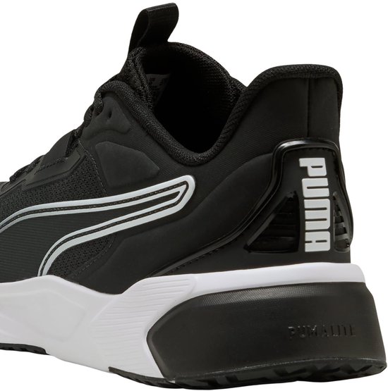 Zij-aanzicht van de zwarte PUMA sportschoen met witte zool en Puma-logo op de hiel.