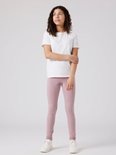 Meisje met krullend haar in wit T-shirt en oudroze legging.