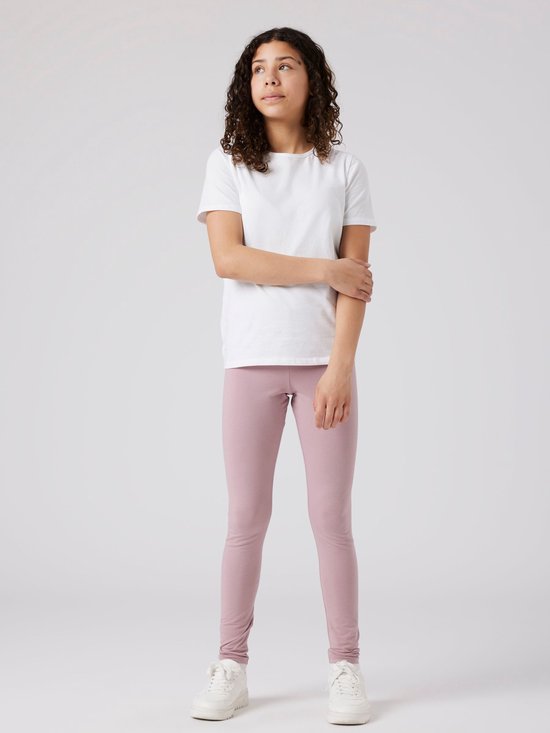 Meisje met krullend haar in wit T-shirt en oudroze legging.