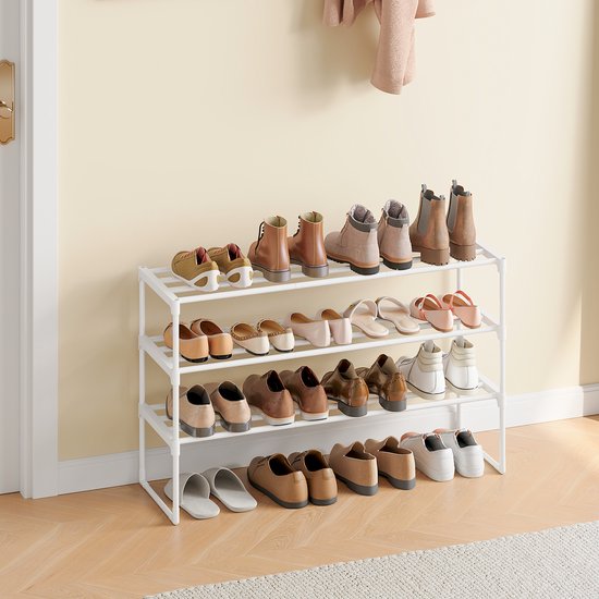 Wit schoenenrek met drie lagen, gevuld met diverse schoenen en laarzen.