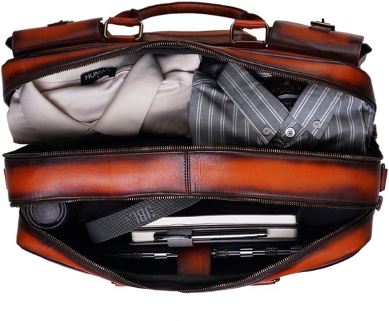 Bovenaanzicht van een open oranje leren aktetas, gevuld met kleding en een laptop.