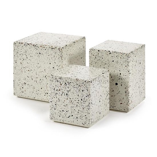Drie kubusvormige bijzettafels van verschillend formaat met een wit terrazzo patroon van grijze, zwarte en bruine spikkels.
