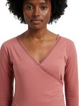 Roze wikkelpyjamatop met kanten afwerking langs de V-hals, gedragen door een model.