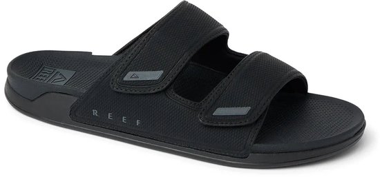 Zwarte Reef slippers met verstelbare bandjes en REEF logo.
