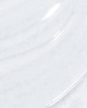 Een close-up van de witte, glanzende textuur van top coat.
