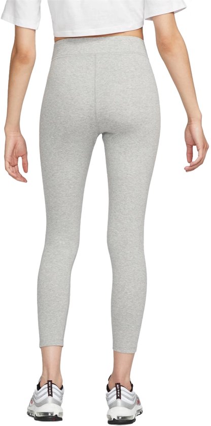Achterkant van een lichtgrijze Nike legging, gedragen door een model met sneakers.