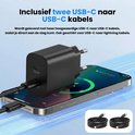 Zwarte 40W USB-C oplader met twee USB-C naar USB-C kabels, liggend op een telefoon.