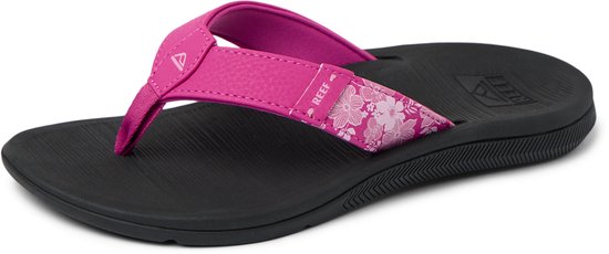 Zwarte Reef slipper met felroze bandje. De band heeft een bloemenprint op de zijkant. Zwarte zool.