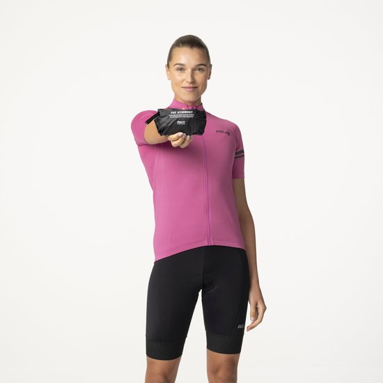 Vrouw in roze fietsshirt houdt opgevouwen zwarte bodywarmer omhoog.