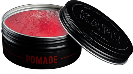 Open blikje zwarte KAPR Pomade met rode gel en een losse deksel.