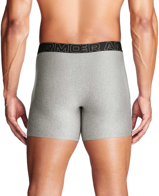 Model in een grijze Under Armour boxer, achterkant, met zwarte logo tailleband.