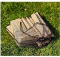 Houten kubben in een zwart netzakje, liggend op groen gras.
