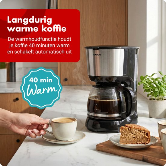 Cafetière Tomado avec verseuse en verre, garde le café au chaud pendant 40 minutes. Une tasse de café et une pâtisserie sont à côté.