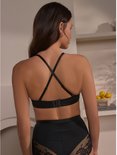 Model draagt zwarte push-up beha zonder bandjes, met gekruiste bandjes aan de achterkant.