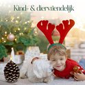 Kind met kerstmuts knuffelt hond naast een bruine dennenappel LED-kaars.