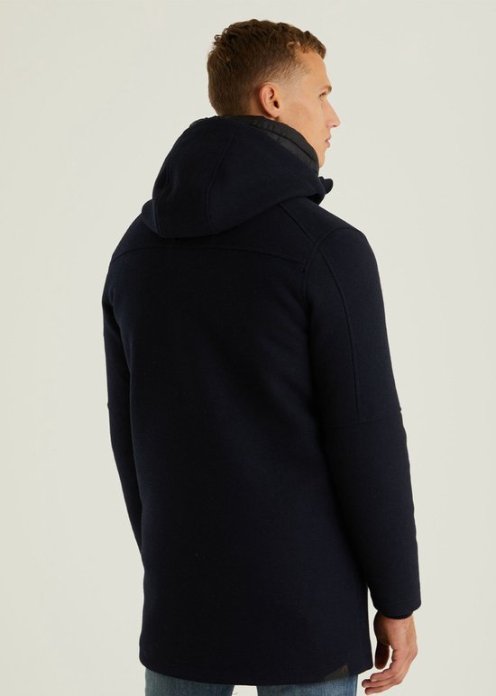 Achterkant van een man in een donkerblauwe wollen parka met capuchon.
