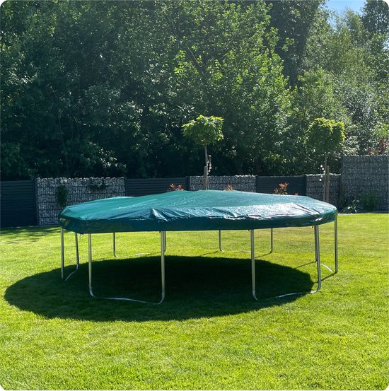 Ronde trampolinehoes in groen, bedekt met een trampoline op een grasveld met schaduw.