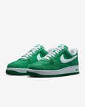 Paar groene Nike Air Force 1 sneakers met witte zolen, witte veters en witte Nike swoosh logo's.