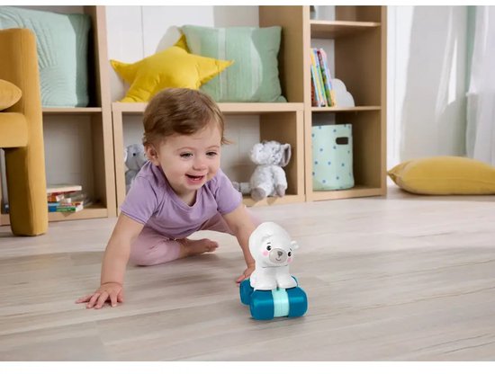 Baby kruipt naar een witte Fisher-Price beer op blauwe wielen, in een kinderkamer.