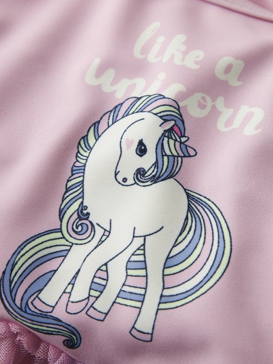 Detail van roze badpak met 'like a unicorn' print: witte eenhoorn met regenboogmanen.