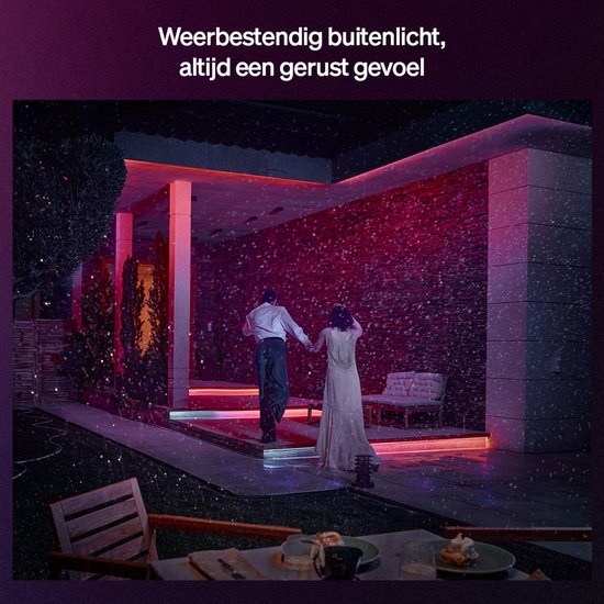 Koppel verlicht de buitentrap en muur met rood licht, terwijl een stel hand in hand loopt.