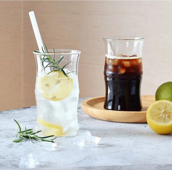 Deux verres aux parois ondulées, remplis de boissons, glaçons, fruits et herbes.