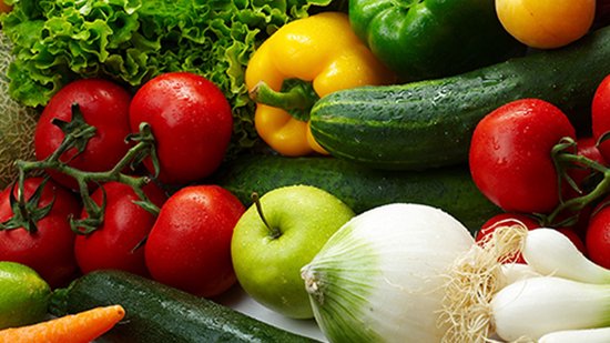 Grote selectie verse groenten en fruit, waaronder tomaten, paprika, komkommer, sla en appels.