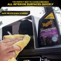 Une main nettoie l'écran d'une voiture avec une lingette jaune, avec une bouteille Meguiar's en arrière-plan.