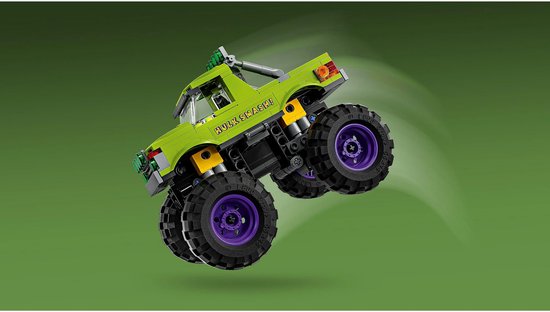 Groene LEGO monster truck met "HULK SMASH!" op de zijkant en paarse velgen, springend op groene achtergrond.