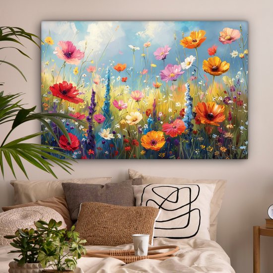 Une peinture d'un champ de fleurs avec des fleurs rouges, oranges et roses au-dessus d'un lit avec de nombreux coussins.