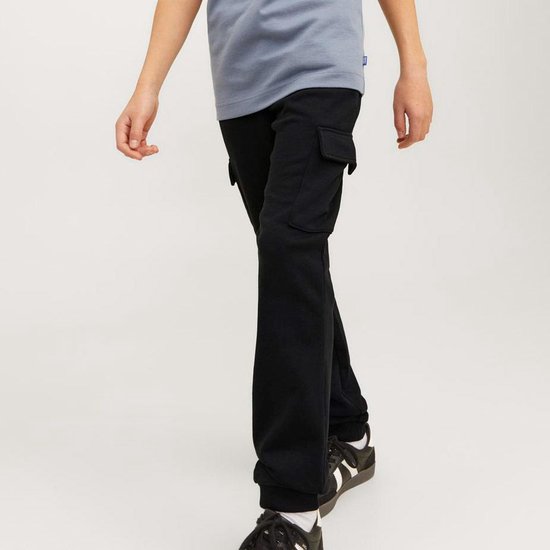 Jongens in zwarte cargobroek en grijze t-shirt, lopen.