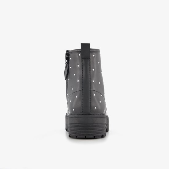Achterkant van een zwarte laars met veters, zilverkleurige studs en een dikke zool.