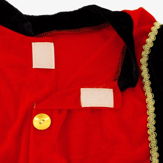 Sluiting van rood fluwelen kinder kostuum met klittenband en goudkleurige knoop.