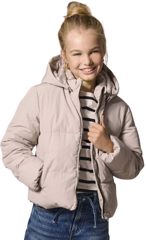 Meisje met opgestoken blond haar en een gestreepte top lacht en trekt haar beige pufferjas recht.