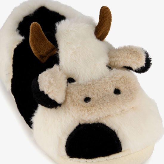 Gedetailleerd koeiengezicht op een zachte, witte pantoffel met zwarte vlekken en bruine hoorns.